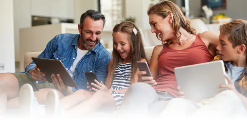 Family all using Internet enabled devices together.